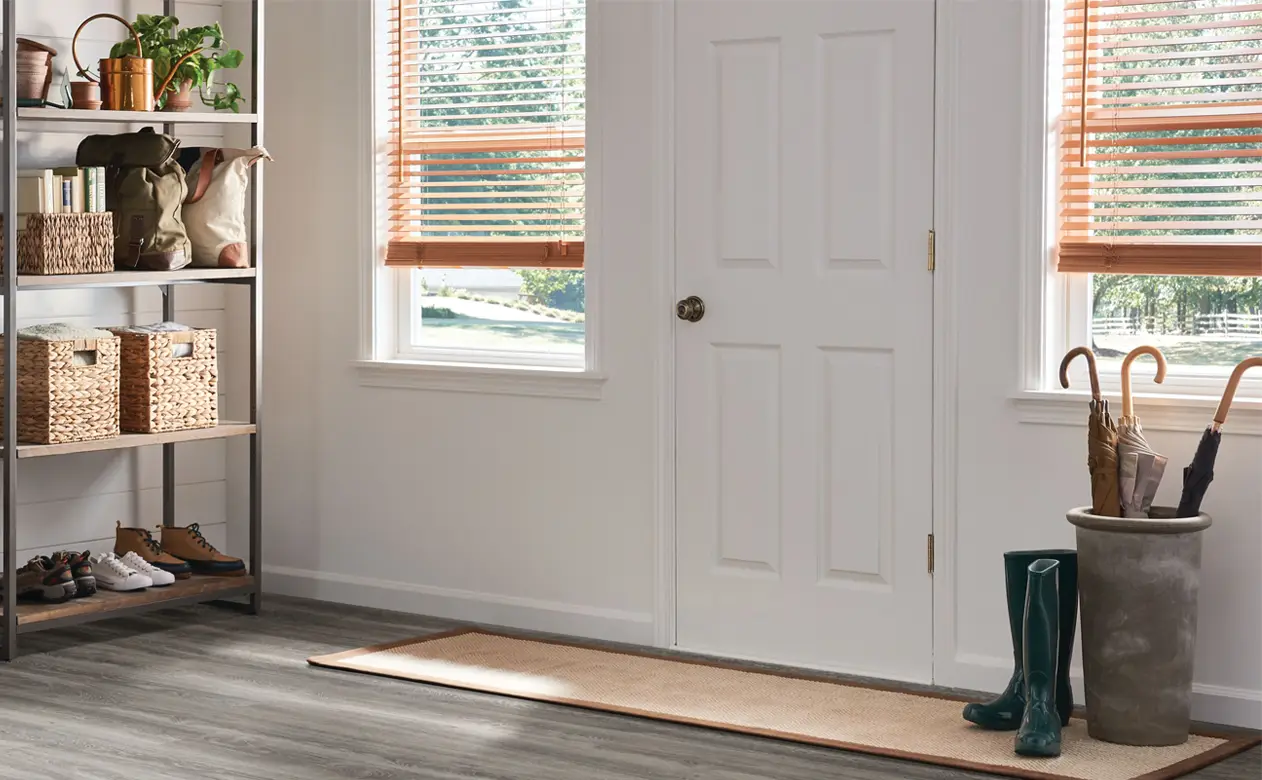 wood blinds in entryway front door hall with gray wood-look flooring