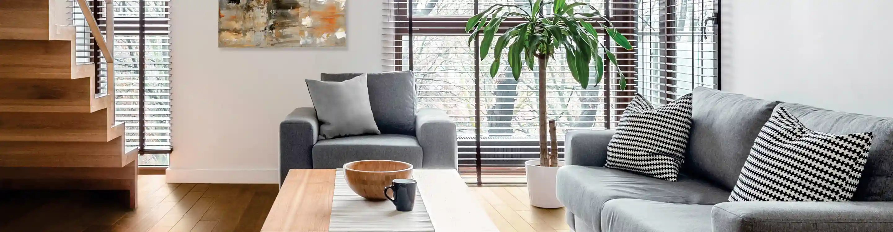 dark brown wood blinds in living room with natural wood floors and gray sofa